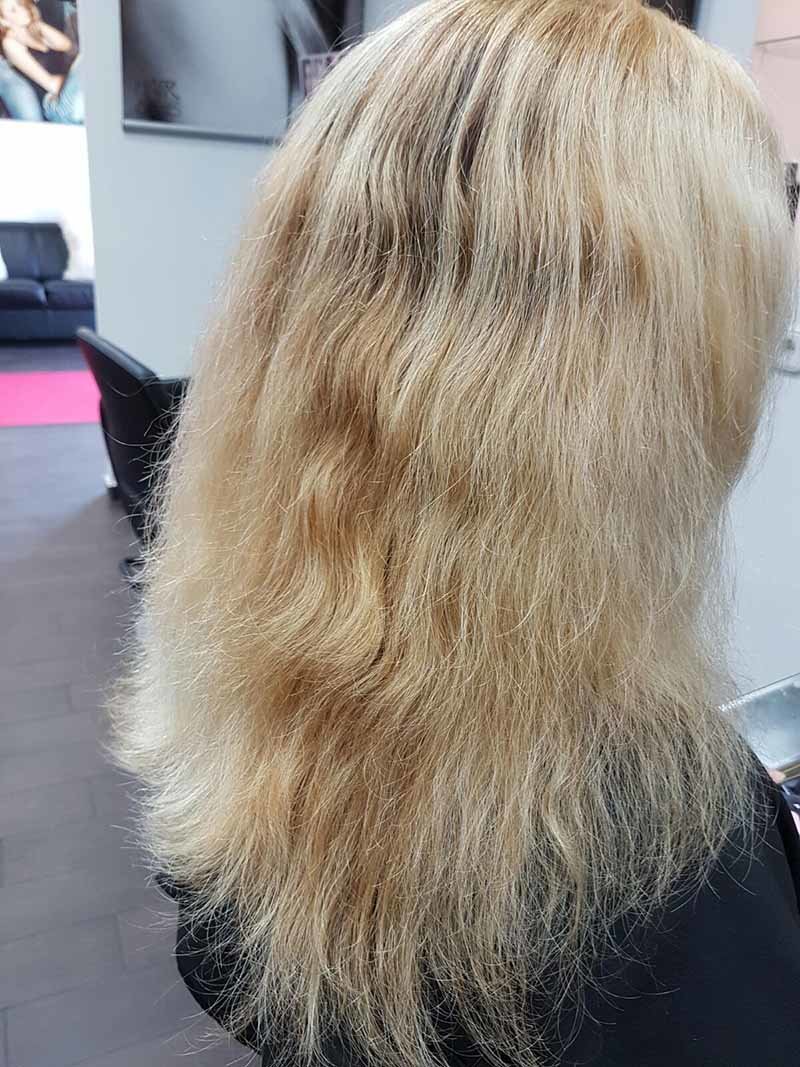 Hellblondes, welliges Haar mit ausgefransten Spliss-Spitzen Langes, hellblondes und welliges Haar mit frizziger Struktur sowie sichtbar ausgefransten, trockenen Spitzen